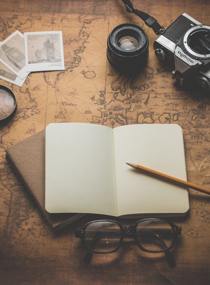 flat ray photography of book, pencil, camera, and with lens