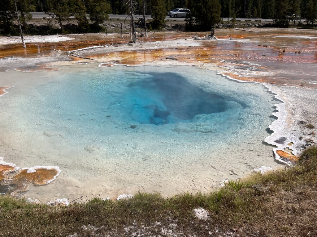 Brilliant blue thermal pool with orange mineral rings, Yellowstone